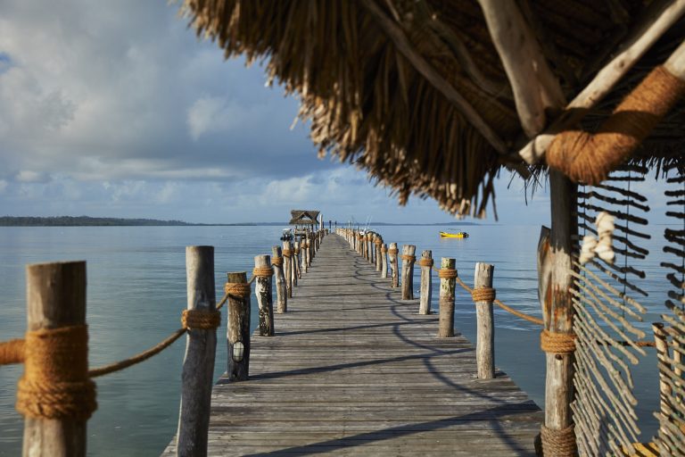 A jetty that leads to the lodge, with a sunrise.